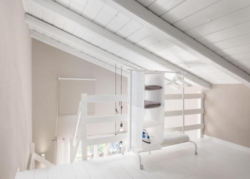 a white loft bed in a white room at Eliathos Hillside Retreat in Archanes