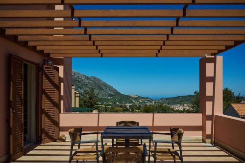 a table and chairs on a balcony with a view at Eliathos Hillside Retreat in Archanes