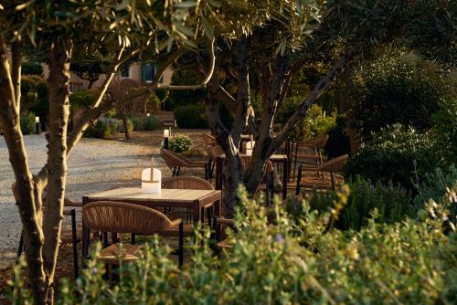 a group of tables and chairs under a tree at Eliathos Hillside Retreat in Archanes