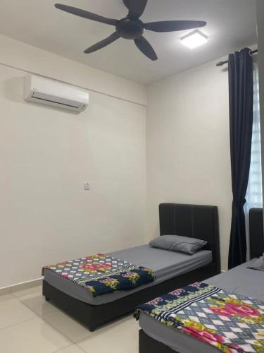 a bedroom with two beds and a ceiling fan at Prima Resident Meru Ipoh in Ipoh