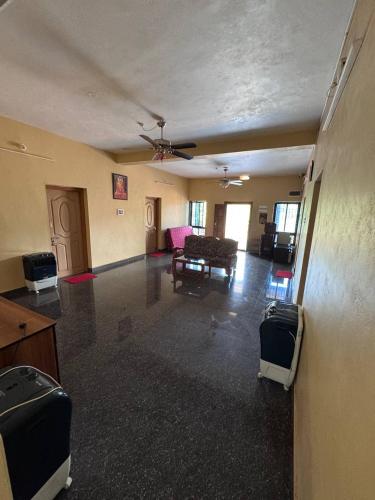an empty living room with a ceiling fan and furniture at Aikya homestay in Gokarna