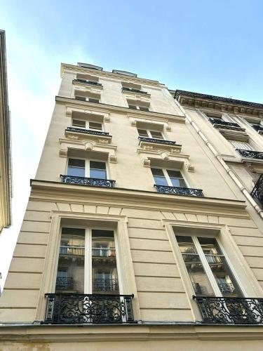 - un grand bâtiment blanc avec des fenêtres et des balcons dans l'établissement Villa SoPi Appart'Hotel by Patrick Hayat, à Paris
