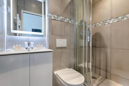une salle de bain avec toilettes et douche en verre dans l'établissement TBS 312 - Charming studio near Marais district, à Paris
