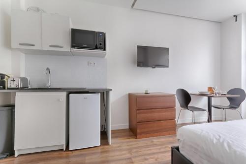 une chambre avec un lit et une cuisine avec une table dans l'établissement TBS 312 - Charming studio near Marais district, à Paris