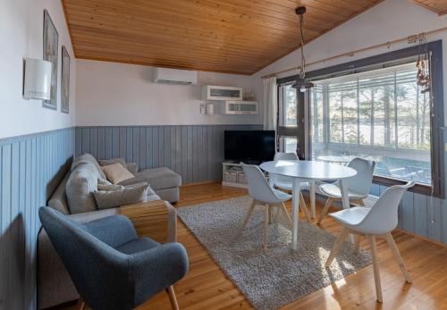 a living room with a couch and a table and chairs at Kraatterimökki in Lappajärvi