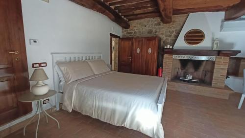 a bedroom with a bed and a fireplace at Romantic suite in the village of Castelleone, vicino Deruta, Assisi, Perugia, Montefalco in Canalicchio