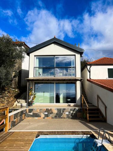 a house with a balcony and a swimming pool at Casinha in Celorico de Basto