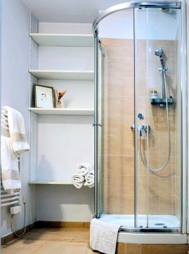 une cabine de douche dans une salle de bain avec des serviettes sur des étagères dans l'établissement Boudoir de la Sagesse, à Périgueux