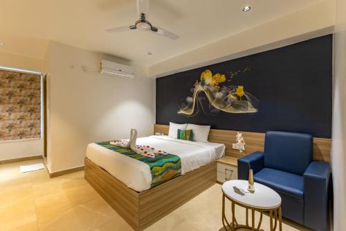 a bedroom with a bed and a blue chair at Hiwa Boutique Hotel in Hyderabad
