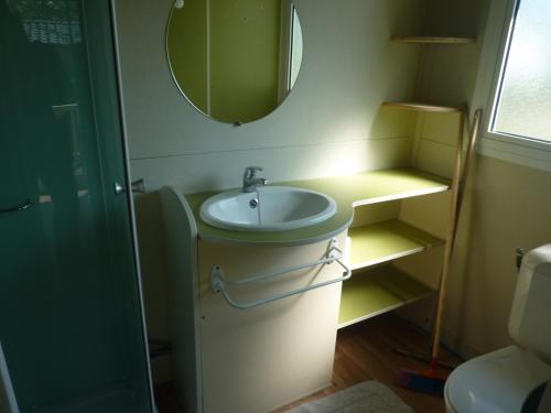 une salle de bain avec un lavabo et un miroir dans l'établissement Camping Pommiers des Trois Pays, à Licques