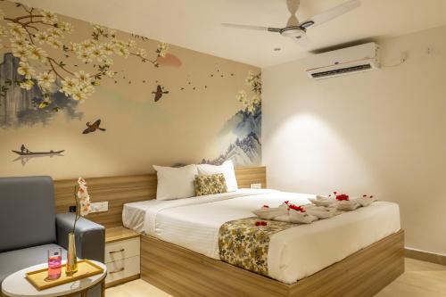a bedroom with a large white bed and flowers on the wall at Hiwa Boutique Hotel in Hyderabad