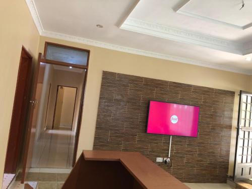 a flat screen tv on a brick wall at Idyllic Inn in Lilongwe