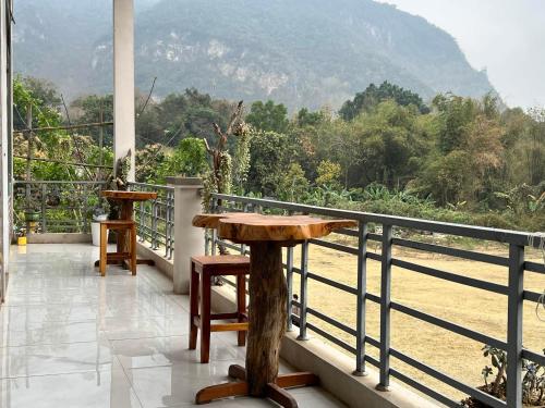 a balcony with a table and a view of a mountain at Mộc Nhiên Homstay Mai Chau in Hòa Bình