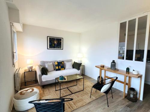 un salon avec un canapé et une table dans l'établissement Charmant appartement 4 personnes à 50m de la plage - balcon vue mer -CELESTE, à Ploemeur