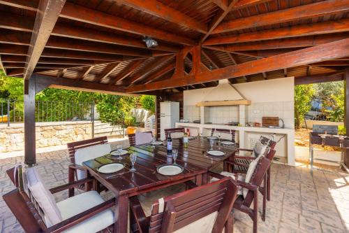 a wooden table and chairs on a patio at Villa Irene Palace in Paphos
