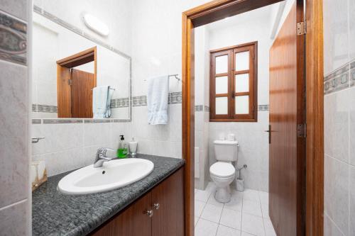 a bathroom with a sink and a toilet and a mirror at Villa Irene Palace in Paphos