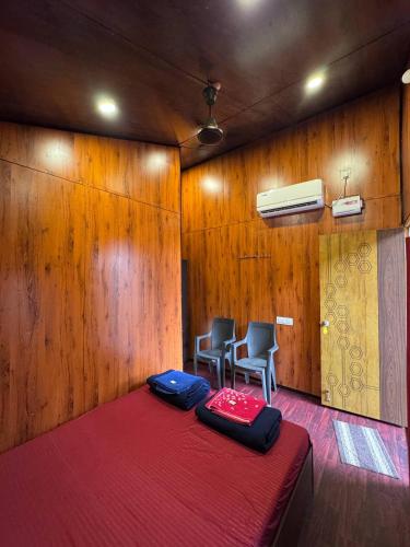 a room with a bed and two chairs in it at Sector 47 Beachfront in Gokarn