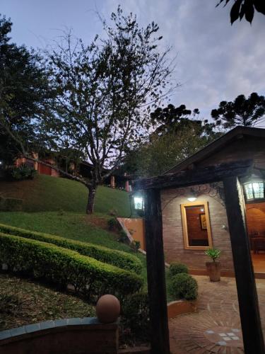 a house with a pathway leading to a yard at Pousada dos Pássaros in Santo Antônio do Pinhal