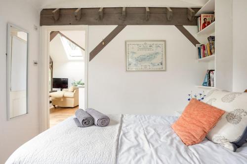 a bedroom with a white bed with towels on it at Churchlands in Kirdford