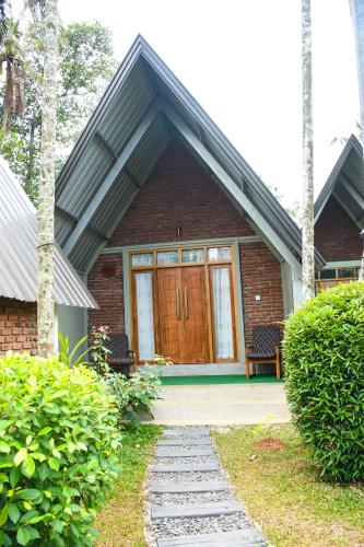 a house with a wooden door and a walkway at Steps Garden Resort in Negombo