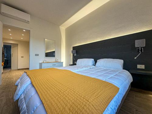 a bedroom with a large bed with a yellow blanket at Al Quarto Piano in Domodossola