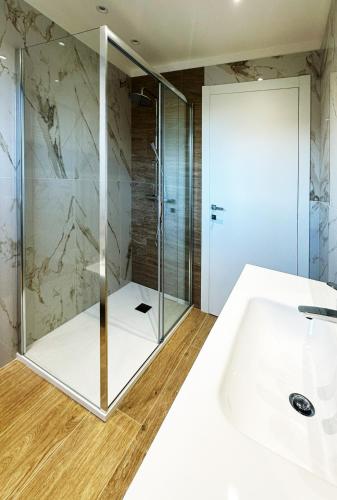 a bathroom with a shower and a white sink at Al Quarto Piano in Domodossola