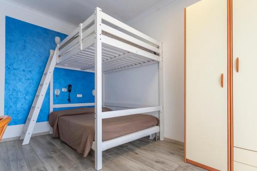 a white bunk bed in a room with a blue wall at Hotel Viking in Rimini