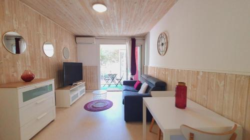 un salon avec un canapé et une table dans l'établissement Studio cosy pour 2 Climatisation au Point Zéro - ROSSIconciergerie - Linge inclus, à La Grande Motte
