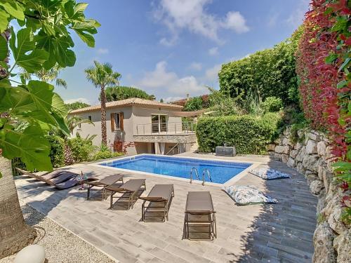 une piscine avec des chaises et une maison dans l'établissement Villa Bamboo Zen, à Cannes