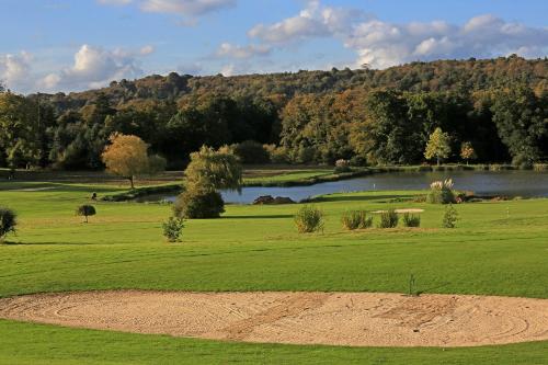 a view of a golf course with a lake at Hôtel de Boisgelin in Pléhédel