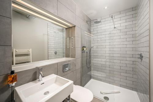 a bathroom with a sink and a toilet and a mirror at Destiny Scotland - Distillers House in Edinburgh