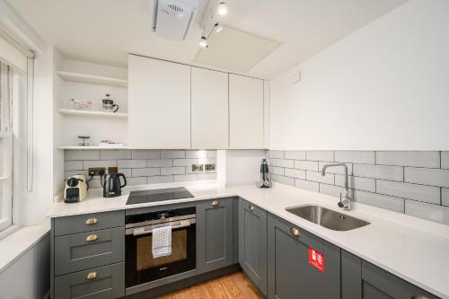 a kitchen with gray cabinets and a sink at Destiny Scotland - Distillers House in Edinburgh