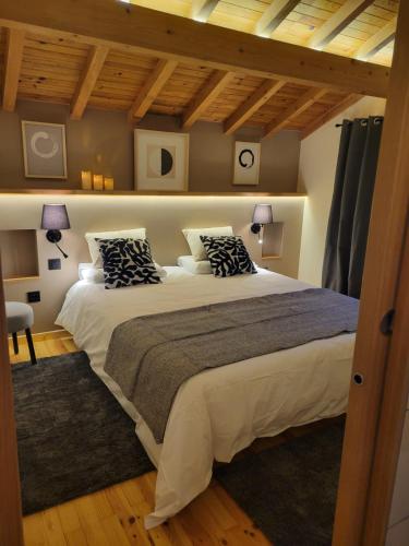 a bedroom with a large bed with two pillows at Loulipo in Gerbépal