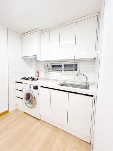 a white kitchen with a sink and a washing machine at HeiStay-30sec from Hongdae SubwayStop-Elevator in Seoul