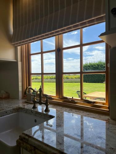 a kitchen with a sink and a large window at Ciel House - French style in Angaston
