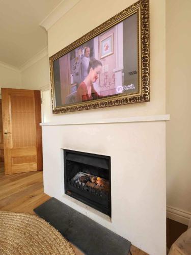 a flat screen tv hanging above a fireplace at Ciel House - French style in Angaston
