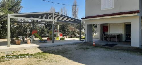 a pavilion with a playground in front of a house at The Villa of the Winds in Néa Kíos