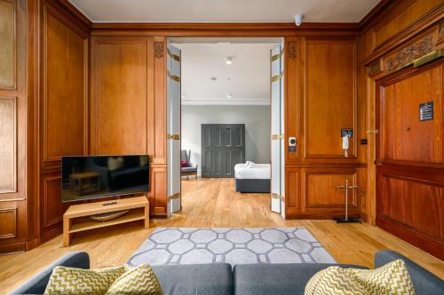 a living room with a couch and a television at Destiny Scotland - Distillers House in Edinburgh
