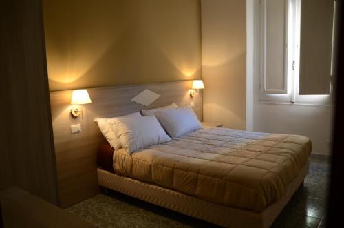 a bedroom with a bed with two lamps on it at Kaliè Rooms Guest House in Cagliari