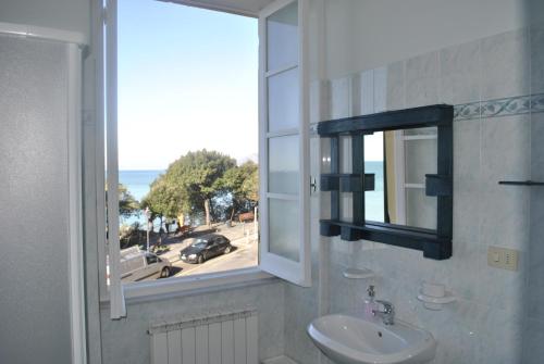 Al Piccolo Scoglio - Room & Breakfast في كامولي: حمام مع حوض ونافذة