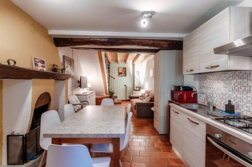 a kitchen and living room with a table and chairs at Willow House by Quokka 360 - in the heart of Sala Comacina in Sala Comacina