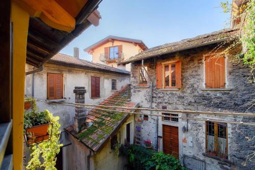an alley of old buildings with red doors and windows at Willow House by Quokka 360 - in the heart of Sala Comacina in Sala Comacina