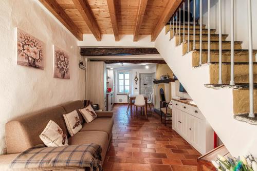 a living room with a couch and a staircase at Willow House by Quokka 360 - in the heart of Sala Comacina in Sala Comacina