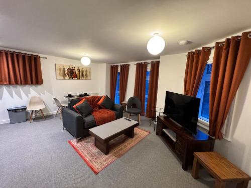 a living room with a couch and a tv at town centre 3, 1st floor, king bed entire flat in Huntingdon