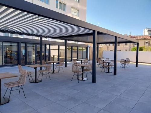 a patio with tables and chairs and awning at Mercure Marseille Centre Prado Vélodrome in Marseille