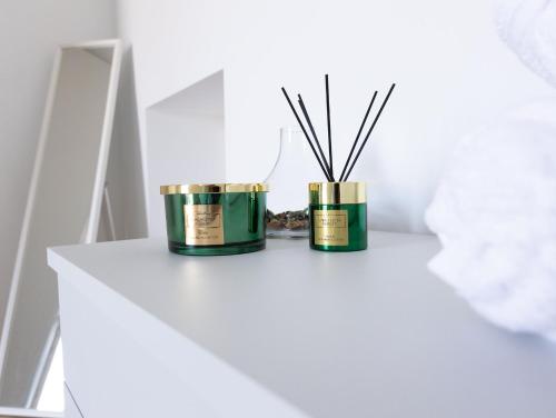 two candles on a white table with sticks at Il Nido Verde Parcheggio Privato Cortile in Piacenza