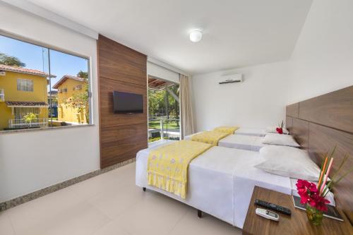 a bedroom with a large bed and a large window at Atlântida Park Hotel in Porto Seguro