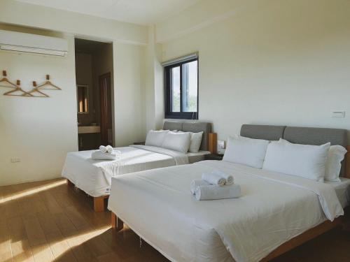 a bedroom with two beds with towels on them at ChuLe Villa x Maobitou in Hengchun South Gate