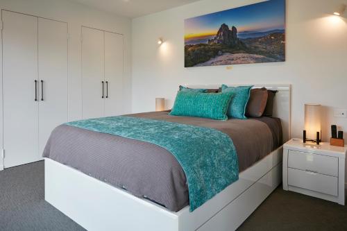 a white bedroom with a large bed and a picture on the wall at Altura Apartment Bright in Bright