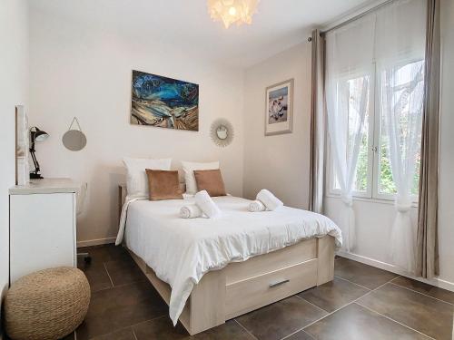 une chambre avec un lit avec des draps blancs et une fenêtre dans l'établissement Villa Bamboo Zen, à Cannes